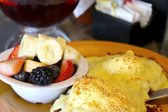 Plate with fruit and two irish benedicts eggs